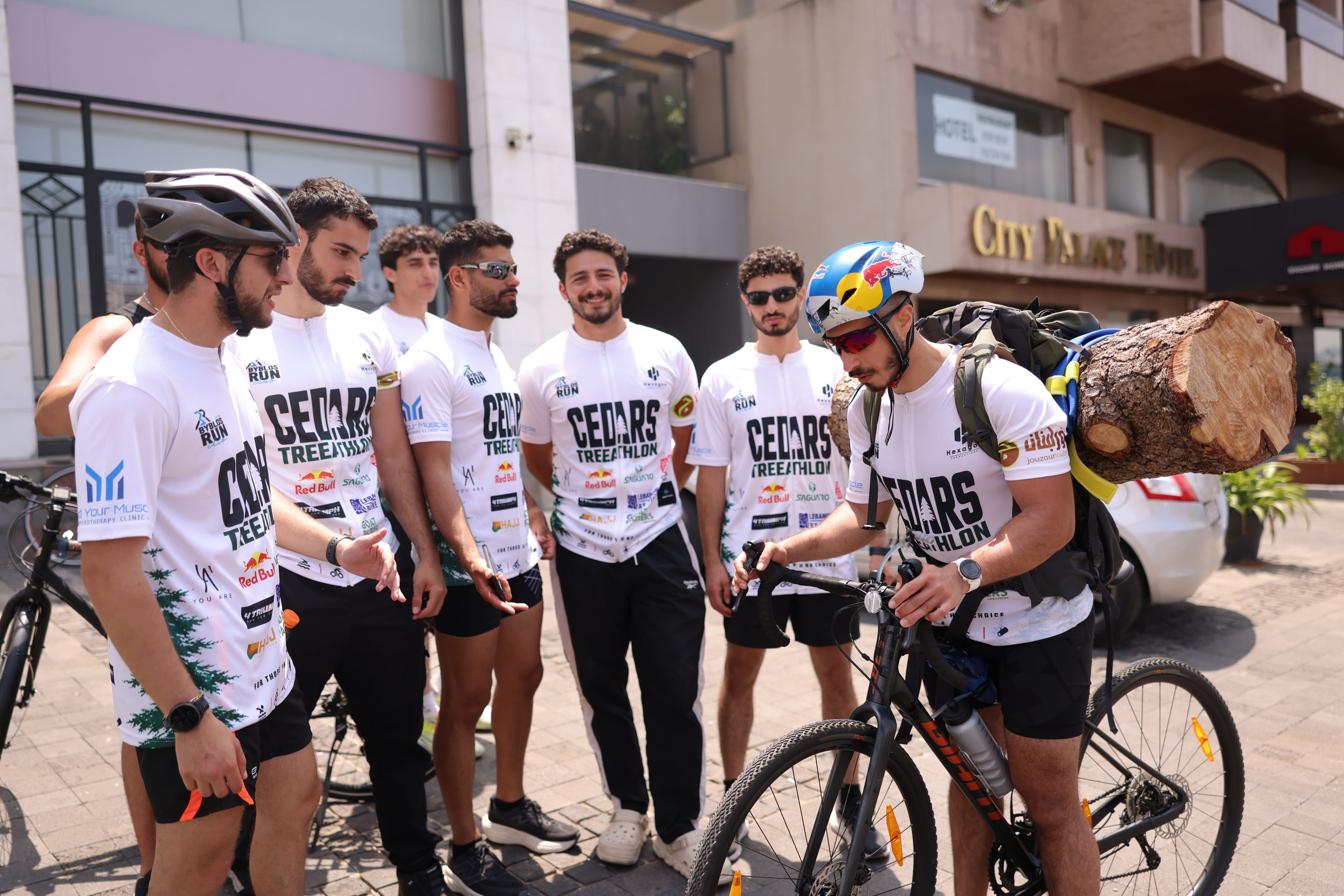 Joe Hachem cycling with a cedar log during the Cedars Treeathlon